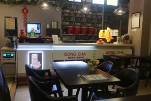 Een restaurantinterieur met een toonbank, stoelen en een menukaart.