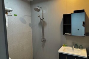Ein Badezimmer mit Dusche, Waschbecken und einem Spiegelschrank.