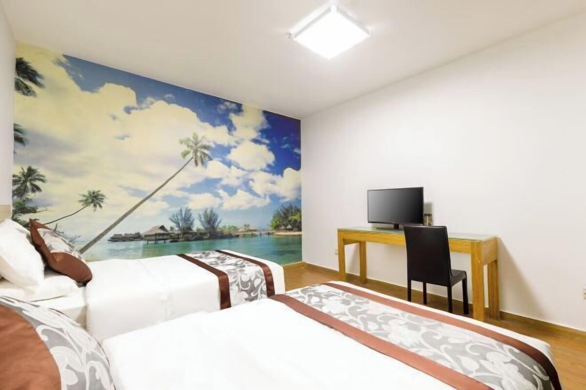 Ein Hotelzimmer mit Bett, Schreibtisch, Sessel und Fernseher.