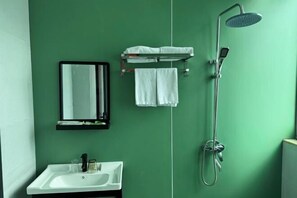 Ein Badezimmer mit Waschbecken, Spiegel, Handtuchhalter und Dusche.
