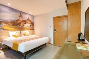 Ein Hotelzimmer mit einem Bett, einer Holztür, einem Glastisch und einem Wandgemälde eines Schlosses.