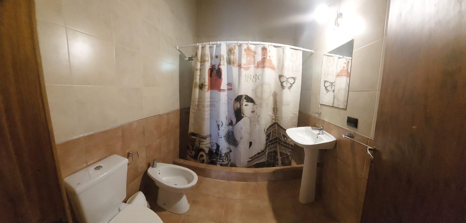 A bathroom with a toilet, bidet, and sink.