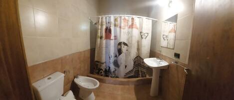 A bathroom with a toilet, bidet, and sink.