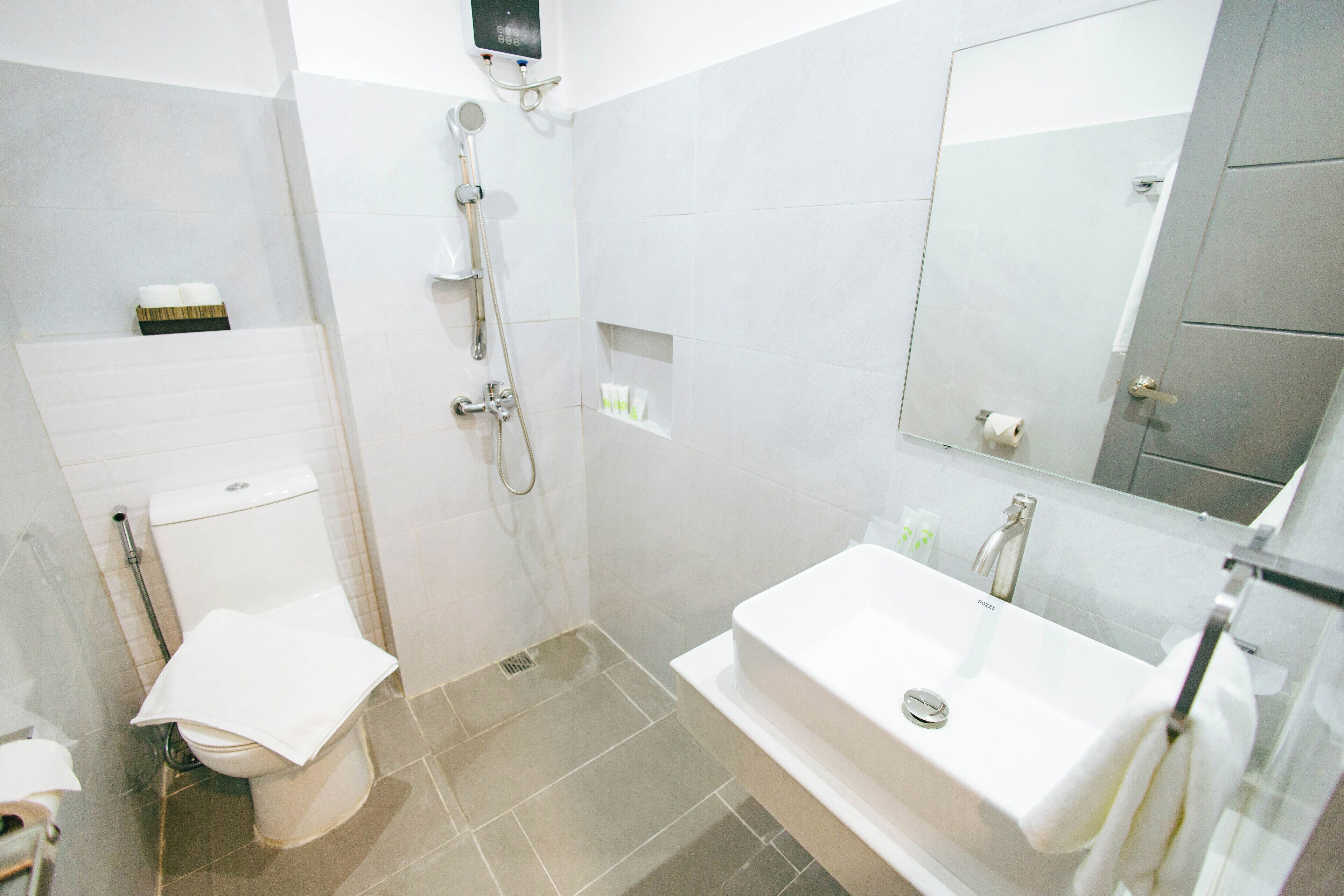 A modern bathroom with a toilet, shower, and sink.