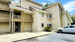 A multi-story building with a covered entrance and a parking area. - Awesome Studio at Bay Tree, 1st floor (Little River)
