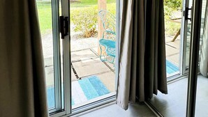 A room with a sliding glass door leading to an outdoor patio area. - Awesome Studio at Bay Tree, 1st floor (Little River)
