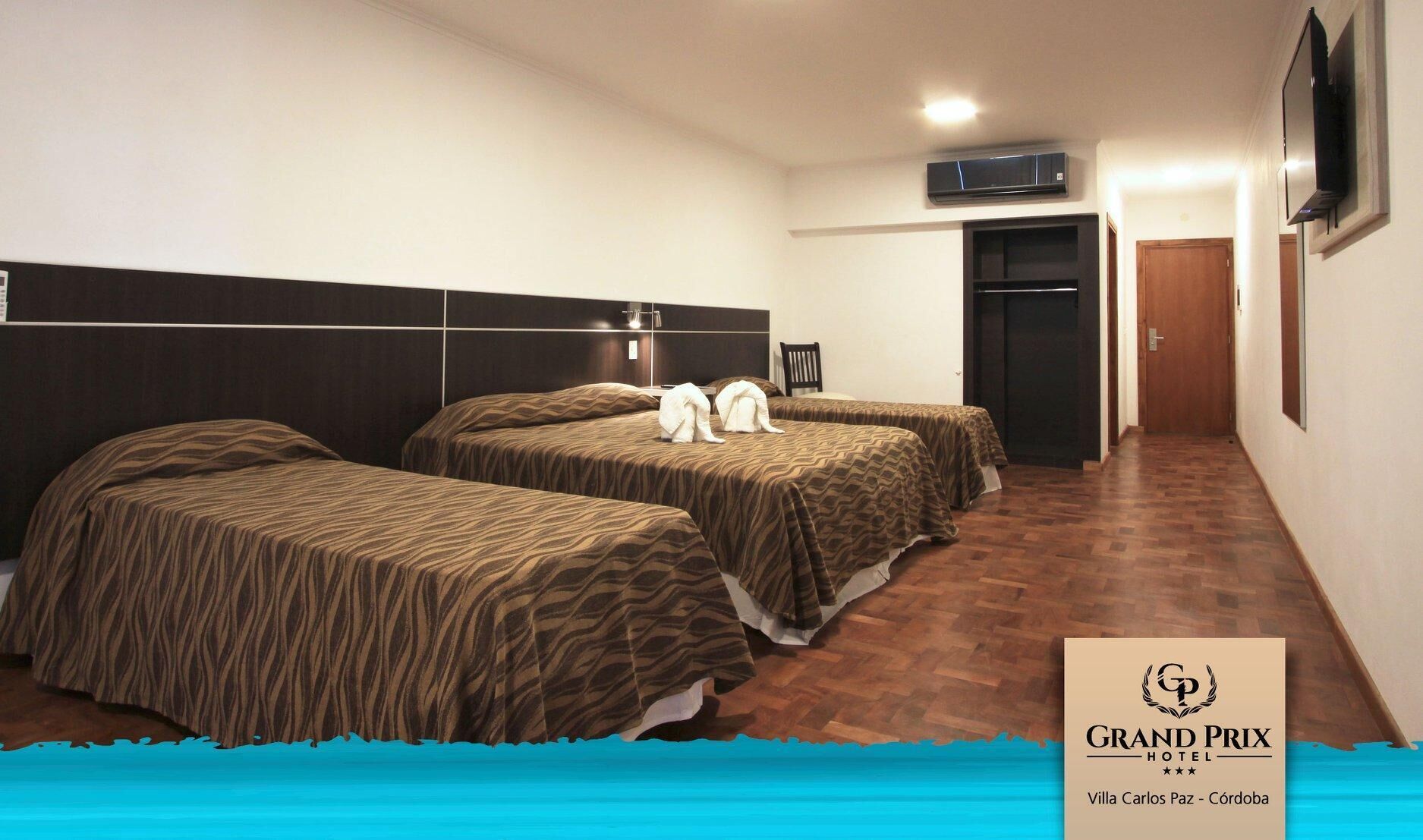 A hotel room with two beds, a flat-screen TV, and a minibar.