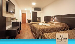 A hotel room with two beds, a TV, a desk, and a mirror. - Hotel Grand Prix (Villa Carlos Paz)
