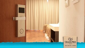 A hotel room with a modern door, a control panel, and a bed. - Hotel Grand Prix (Villa Carlos Paz)