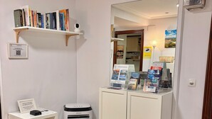 A room with a white bookshelf, a white cabinet, a white radiator, and a mirror on the wall. - PENSIÓN SANTA CLARA SAN SEBASTIAN (San Sebastián)