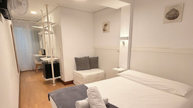 A hotel room with a bed, bedside table, and a chair. - PENSIÓN SANTA CLARA SAN SEBASTIAN (San Sebastián)
