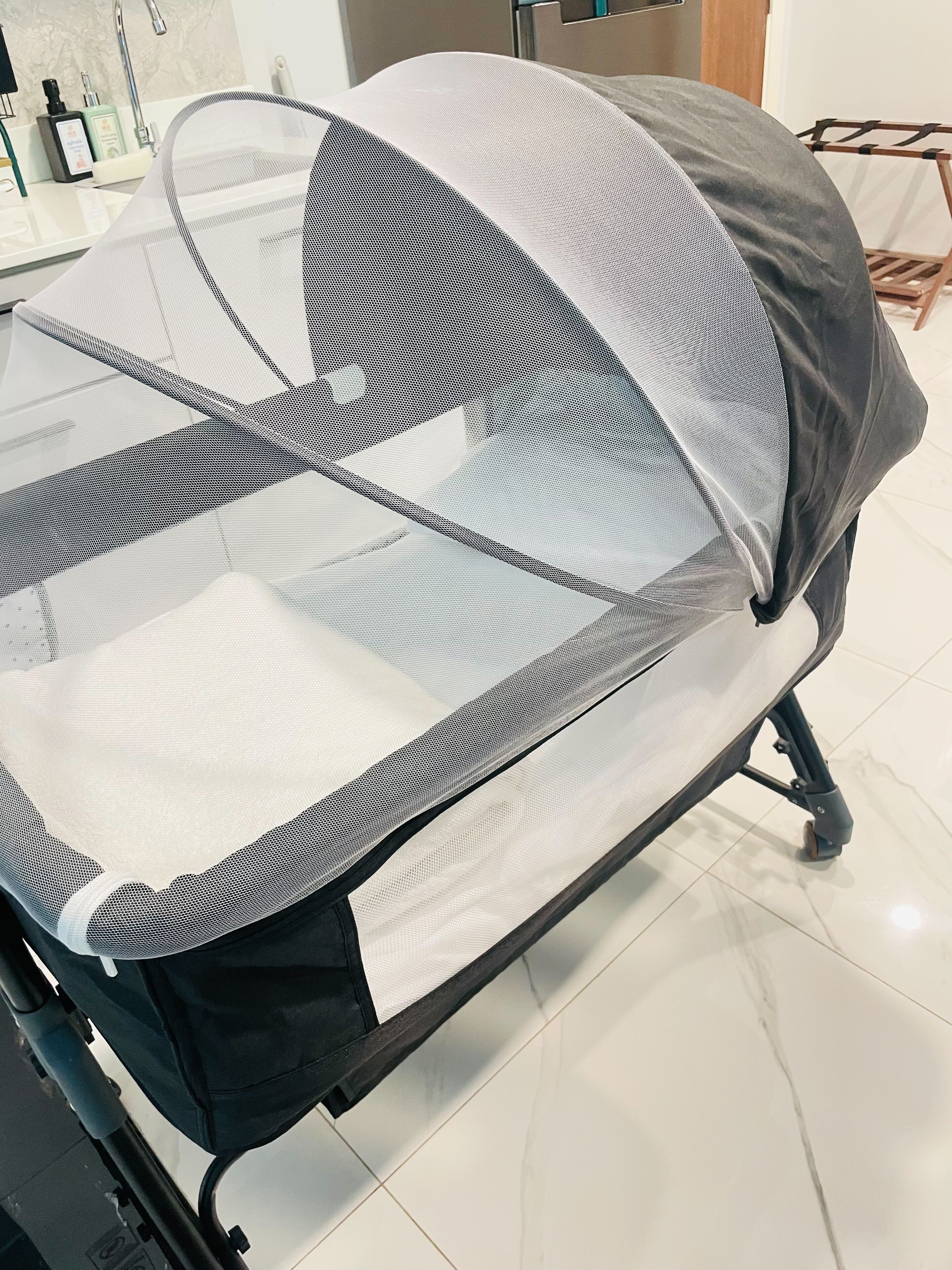 A chair with a mesh backrest and a solid backrest, positioned on a tiled floor.
