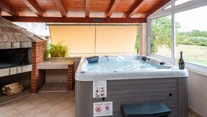 A hot tub under a wooden pergola with a view of the outdoors. - Apartment Nature View near Dubrovnik (Zupa dubrovacka)