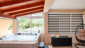 A hot tub under a wooden ceiling with a view of greenery outside. - Apartment Nature View near Dubrovnik (Zupa dubrovacka)