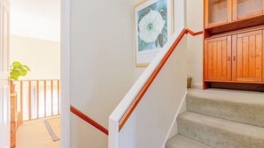 A staircase with a wooden handrail, carpeted steps, and a framed picture on the wall. - Delightful 3BD Family Home w Garden, Finsbury Park (Greater London)
