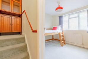 A room with a bunk bed, a wooden staircase, and a window with blinds. - Delightful 3BD Family Home w Garden, Finsbury Park (Greater London)