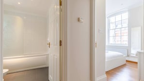A bathroom with a bathtub, a toilet, and a shower. - Stylish 1BR Flat by Museums in South Kensington (Greater London)