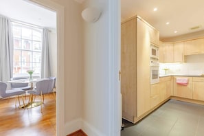 A modern kitchen with wooden cabinets, a microwave, and a sink.
