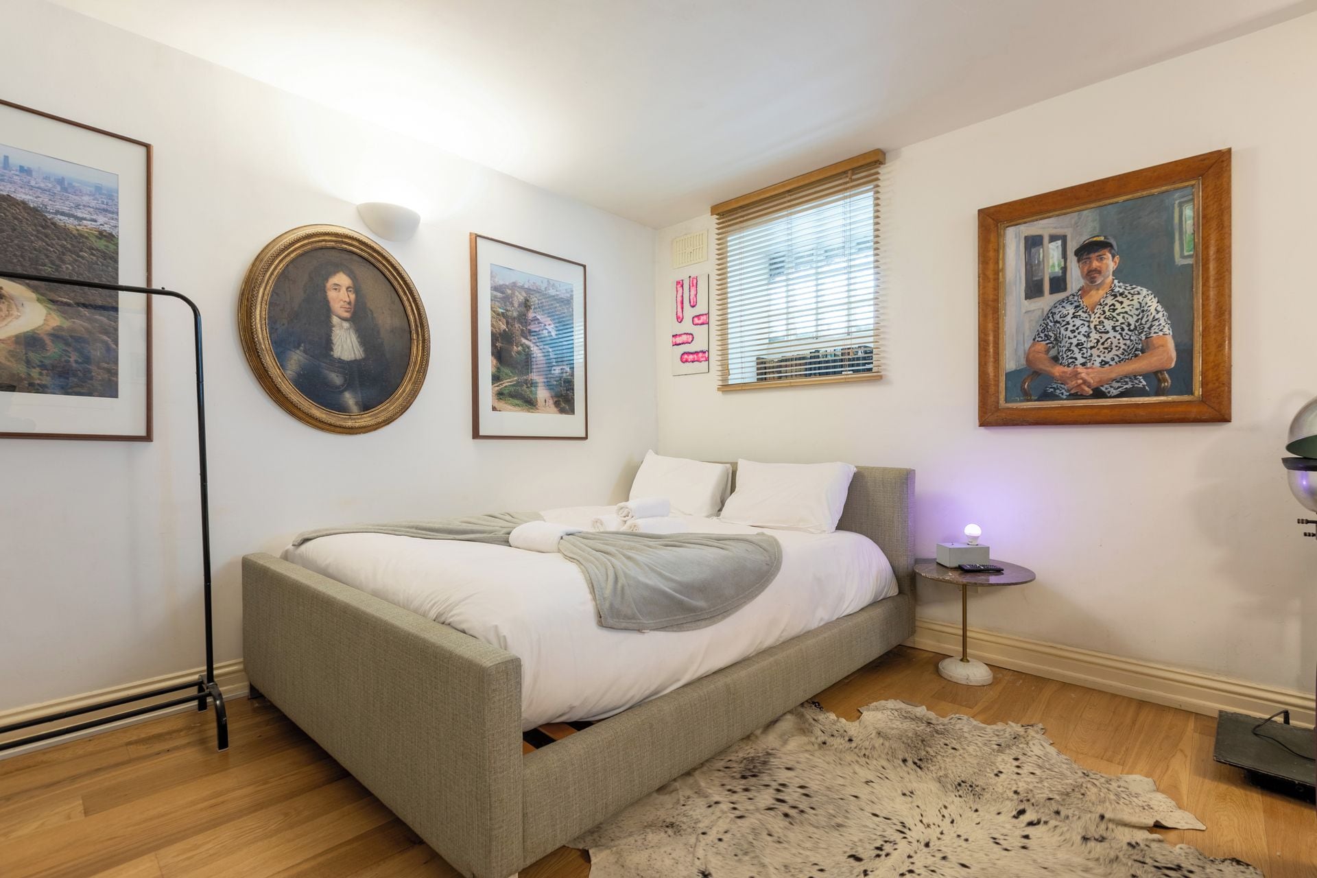 Une chambre à coucher avec un lit, un tapis et des tableaux encadrés accrochés au mur.