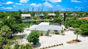 A residential area with houses, a swimming pool, and a dock. - Island Sanctuary: Canal Home with Pool, Pets OK! (Sanibel)