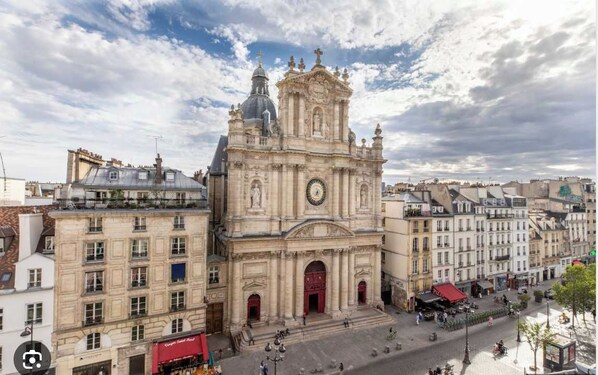 A historic building with a prominent clock tower and classical architecture. - Sublim Apartment 4 chambres Paris Le Marais (Paris)