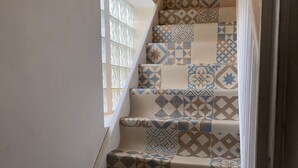 A staircase with patterned tiles in shades of beige, blue, and brown. - PARISIAN FOREST  (Cesson)