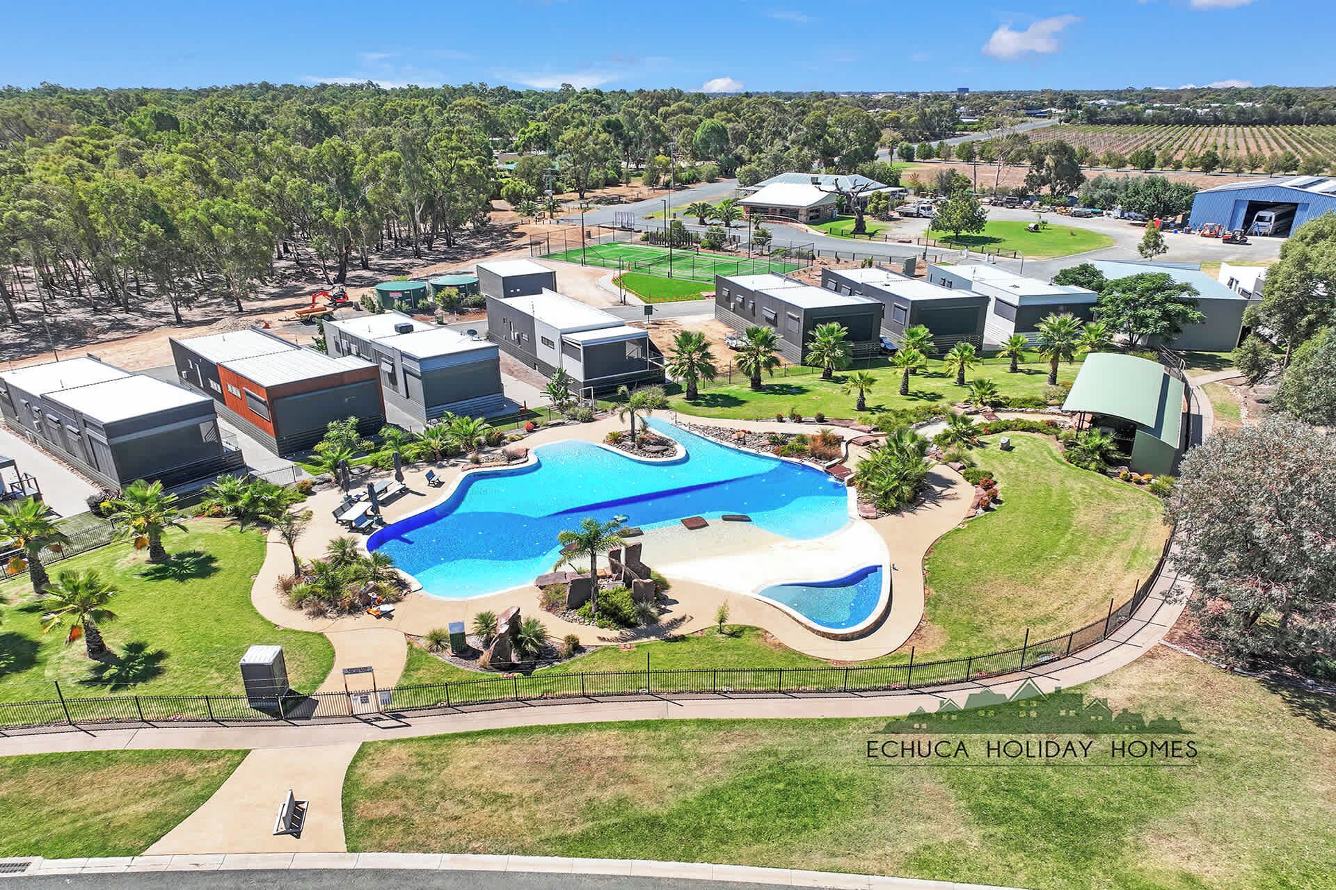 A residential area with modern houses, a swimming pool, and a well-maintained lawn.