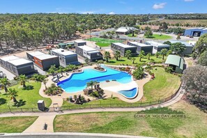 A residential area with modern houses, a swimming pool, and a well-maintained lawn.