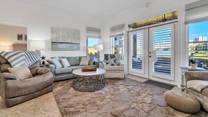 A spacious living room with a large sofa, a coffee table, and a ceiling fan. - Lakefront 402, Upgraded 3-bd, 3-bath lakefront villa just steps to the beach! (Miramar Beach)