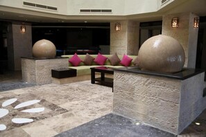 A lobby with a seating area, large decorative spheres, and a patterned floor. - La Rosa Boho Aquapark Hotel (Hurghada)