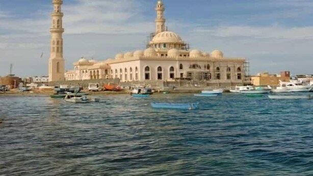 A mosque with two minarets and a dome, situated by a body of water with boats. - La Rosa Boho Aquapark Hotel (Hurghada)