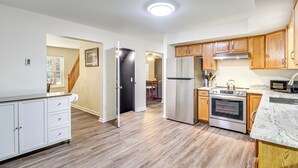 Una cocina con armarios de madera, un refrigerador de acero inoxidable, un horno y un microondas.