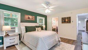 Un dormitorio con cama, mesita de noche y ventilador de techo.