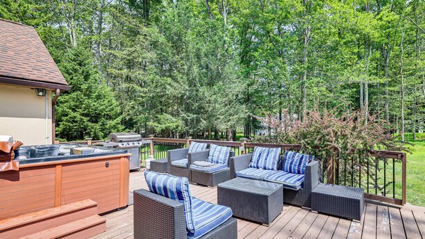 A deck with outdoor furniture, a hot tub, and a barbecue grill. - Hot Tub + Fire Pit: Pocono Summit Home! (Pocono Summit)
