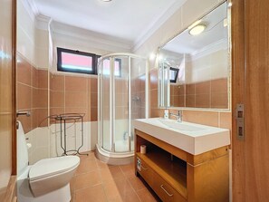 Une salle de bain moderne équipée de toilettes, d’un lavabo et d’une douche.