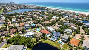 Luchtbeeld van een woongebied met huizen, een meer en een strand.