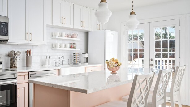 A modern kitchen with white cabinets, a marble countertop, and a central island with chairs. - Resort-Style 3BR/3BA • Pool & Spa • Gated (Houston)
