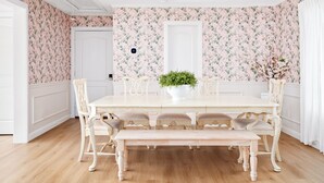 A dining room with a white table, matching chairs, and a bench. There is a potted plant on the table. - Resort-Style 3BR/3BA • Pool & Spa • Gated (Houston)