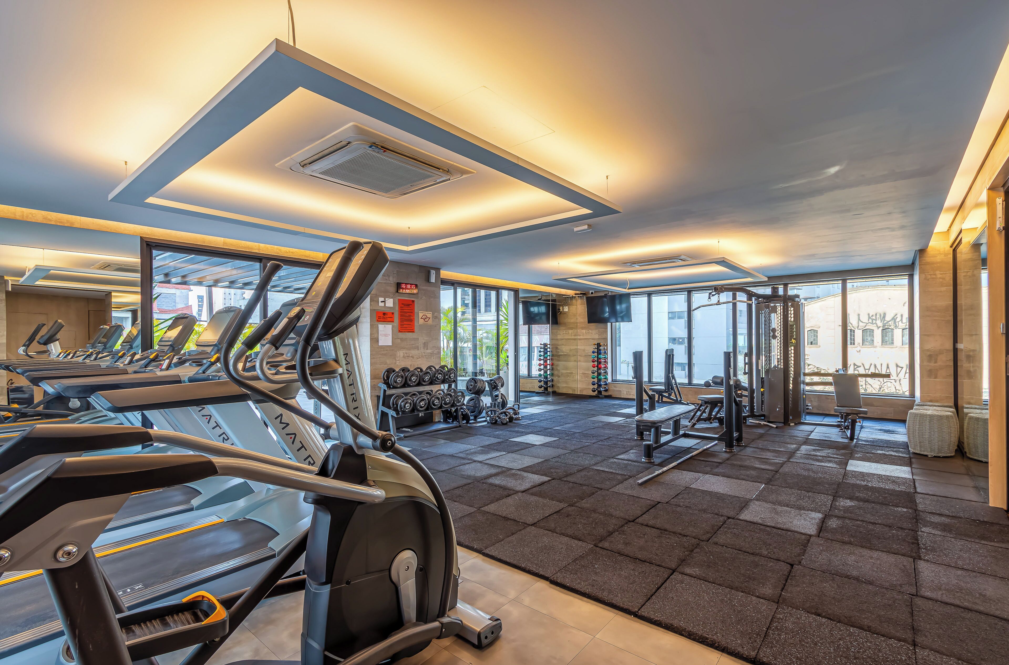 Une salle de sport équipée de tapis de course, d’haltères et d’appareils de musculation.