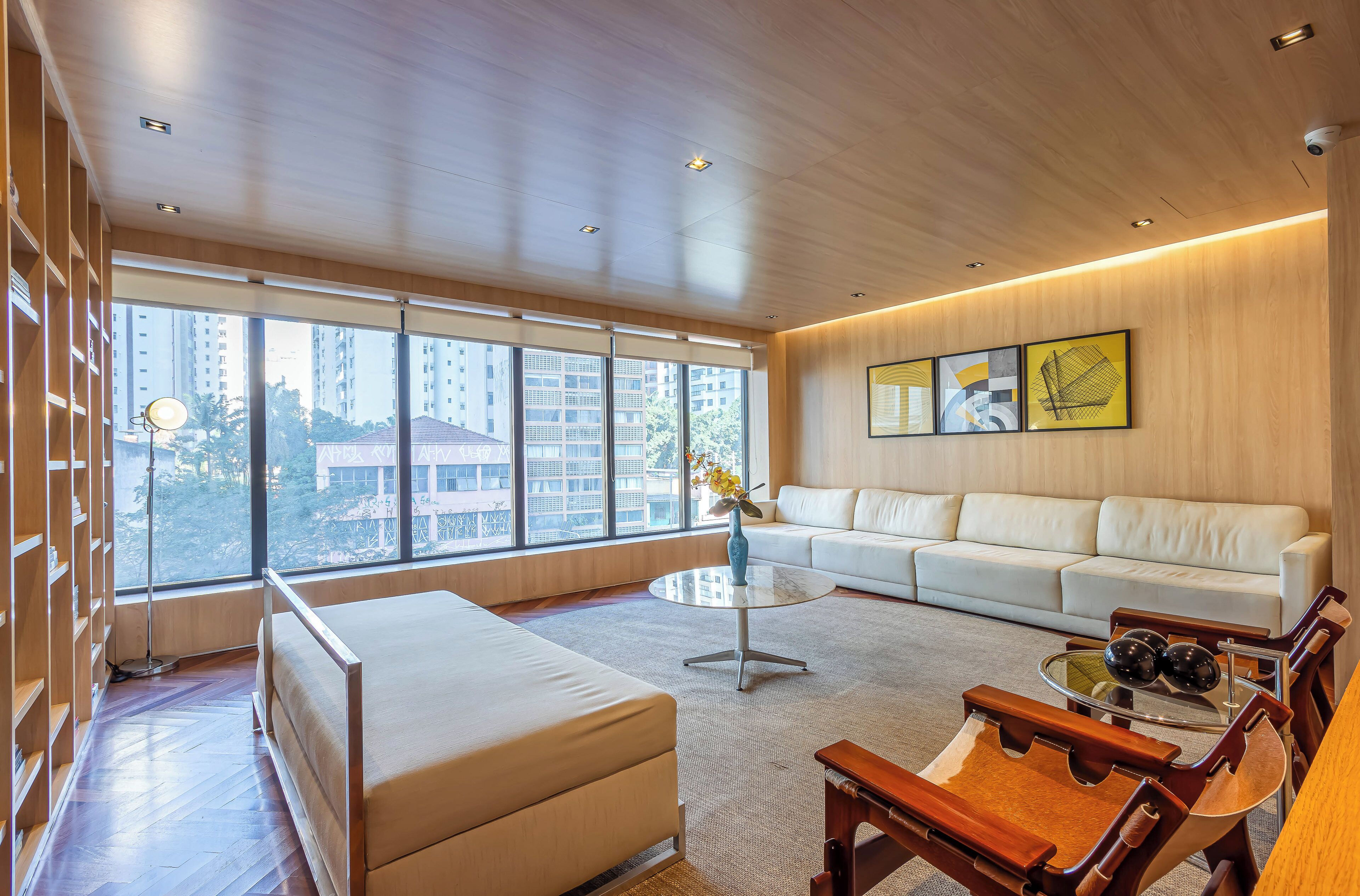 A modern living room with a sofa, a coffee table, and wooden chairs.