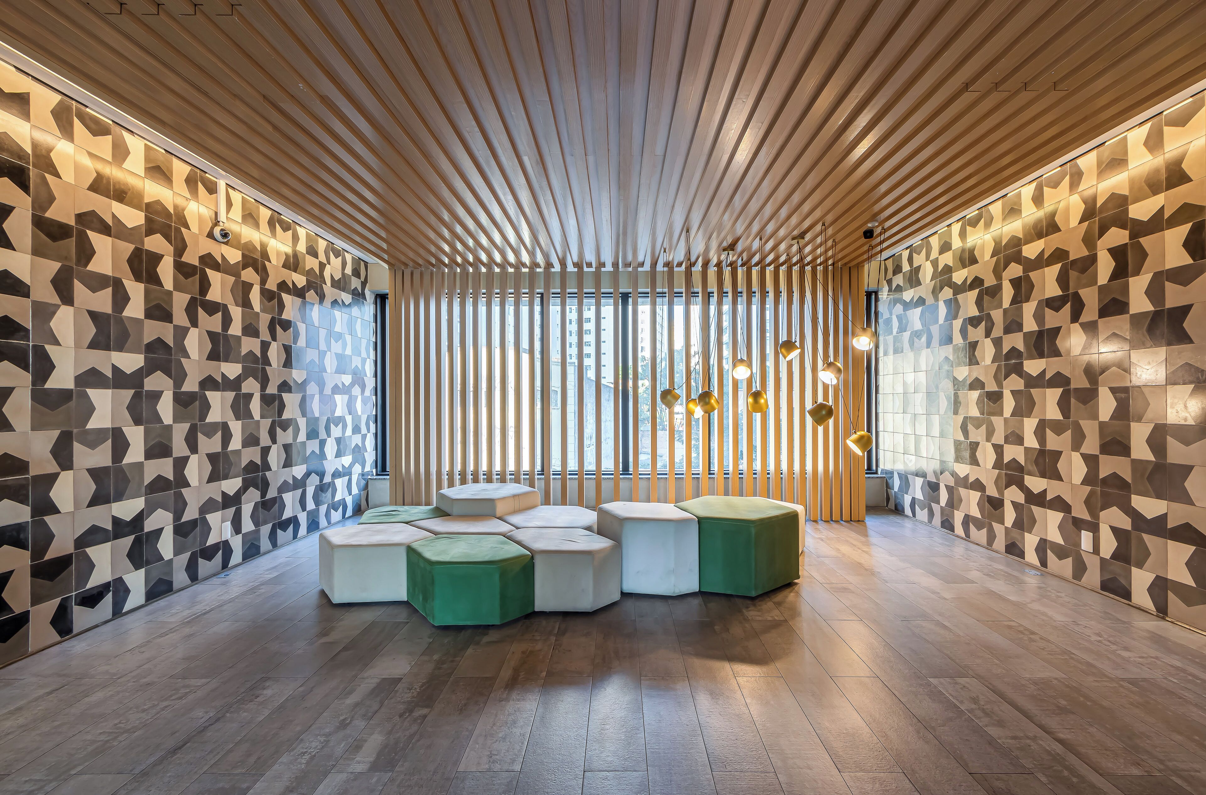 Un intérieur moderne avec des murs aux motifs géométriques, un plafond à lattes de bois et des sièges hexagonaux.
