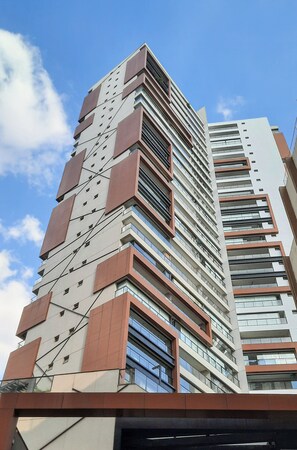 A high-rise building with multiple floors, large windows, and a modern architectural design. - Helbor Nun Vila Nova by Viva - Apartamentos completos próximo ao Parque do Ibirapuera (São Paulo)