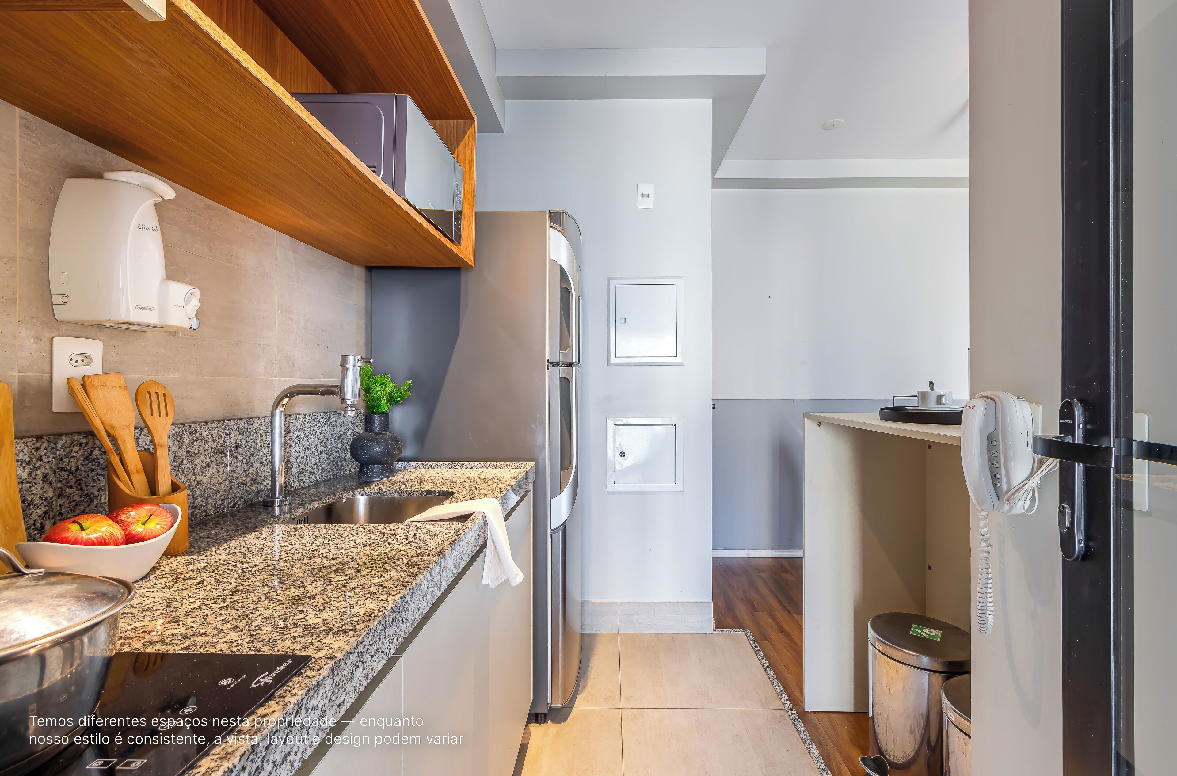 Una cocina moderna con encimeras de granito, electrodomésticos de acero inoxidable y estantes de madera.