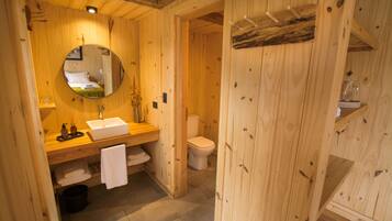 Un baño de madera con lavamanos, espejo y retrete.