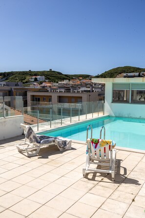 A rooftop pool with two lounge chairs, a clear view of the surrounding buildings, and a tiled floor. - Sunrise - Com Vista Para a Vila (Alcobaça)