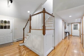 A staircase with wooden balusters and a white wall.