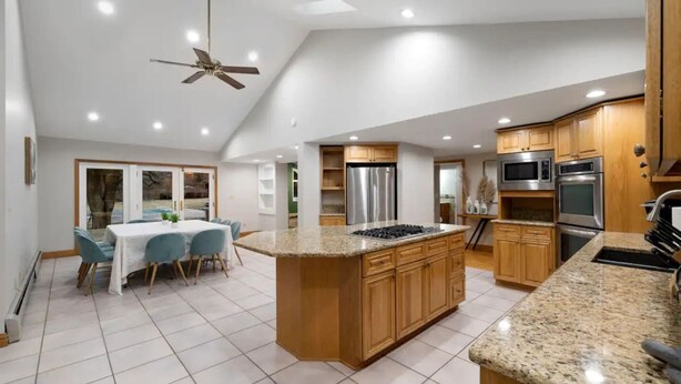 A modern kitchen with granite countertops, stainless steel appliances, and wooden cabinets.