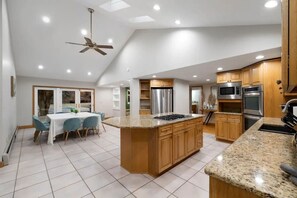 A modern kitchen with granite countertops, stainless steel appliances, and wooden cabinets. - Group Spring Retreat | Fun Games & Gourmet Kitchen (Suffern)