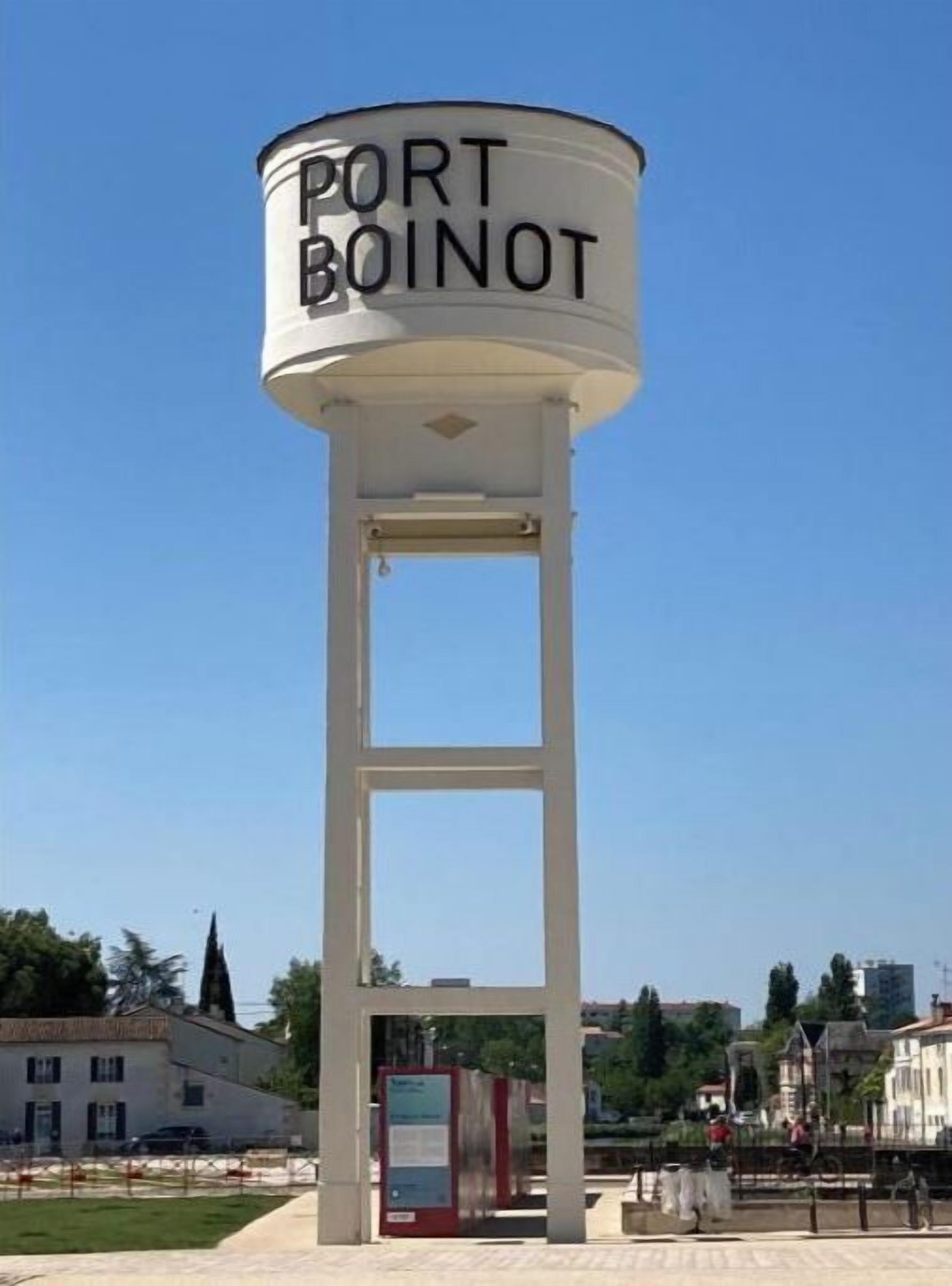 Une haute tour à eau blanche, sur laquelle on peut lire l’inscription « PORT BOINOT ».