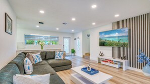 Una sala de estar moderna con un sofá modular, una mesa de centro y un televisor montado en la pared.